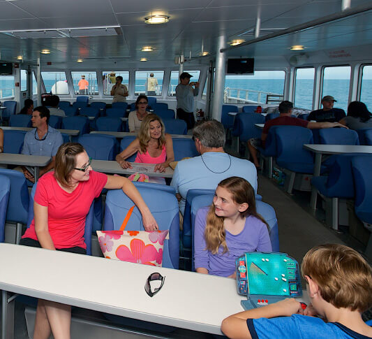 Mom smiling at her daughter while both seated at a table while onboard the Yankee Freedom on route to the Dry Tortugas